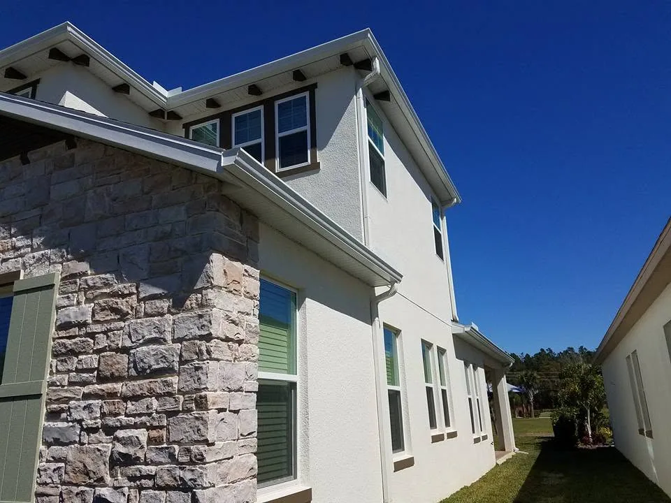 Side elevation white stucco two story stone veneer corner white gutters, Sanford